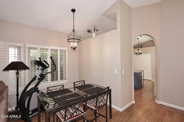 dining room with hardwood / wood-style floors and a notable chandelier