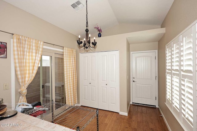 bedroom featuring an inviting chandelier, a closet, hardwood / wood-style floors, and lofted ceiling