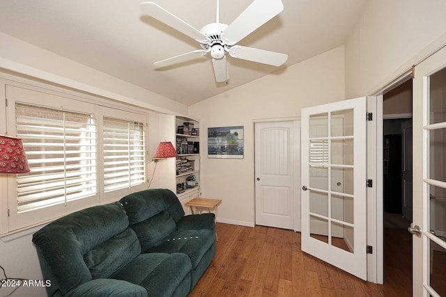 living room with ceiling fan, vaulted ceiling, and hardwood / wood-style floors