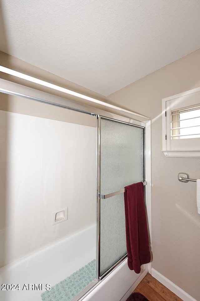 bathroom featuring shower / bath combination with glass door and wood-type flooring