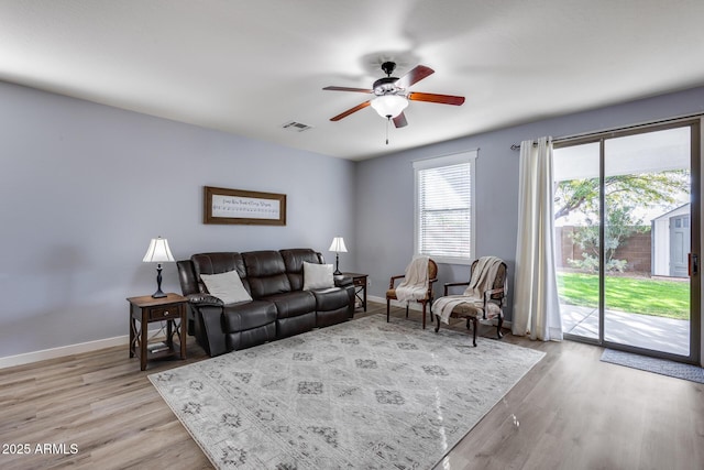 living room with ceiling fan and light hardwood / wood-style flooring