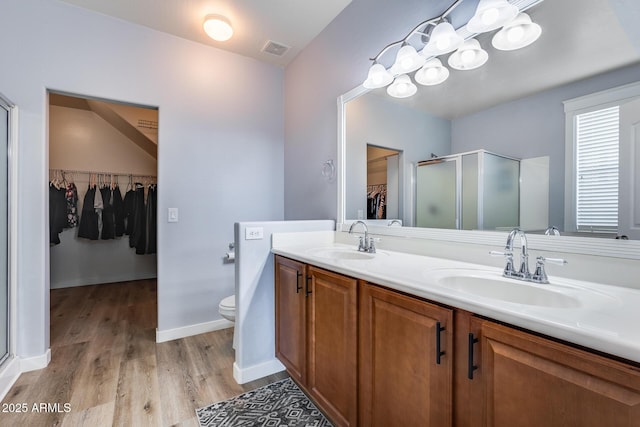 bathroom featuring vanity, wood-type flooring, toilet, and walk in shower