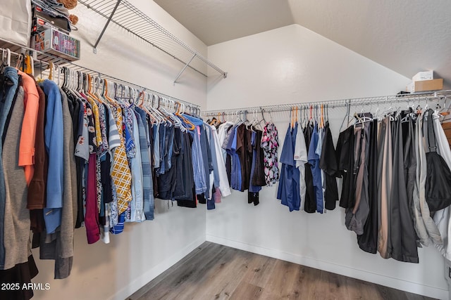 walk in closet featuring wood-type flooring and lofted ceiling