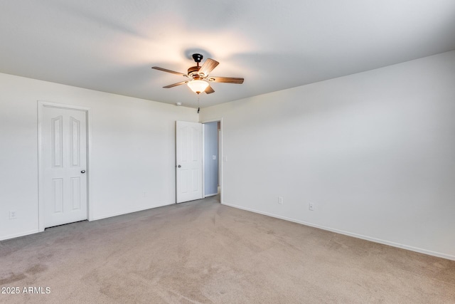 unfurnished room with light colored carpet and ceiling fan