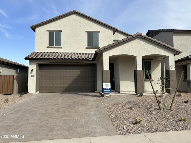 view of front of house featuring a garage, decorative driveway, and stucco siding