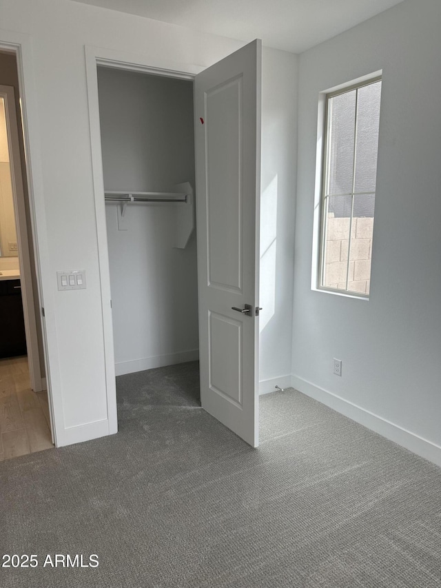 unfurnished bedroom featuring carpet floors, a closet, and baseboards