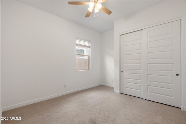 unfurnished bedroom with a closet, baseboards, carpet floors, and ceiling fan