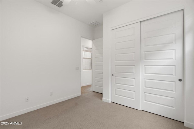 unfurnished bedroom featuring visible vents, carpet, baseboards, and a closet