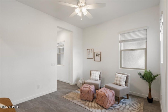 sitting room with baseboards and ceiling fan