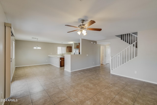 unfurnished living room featuring light tile patterned flooring and ceiling fan with notable chandelier