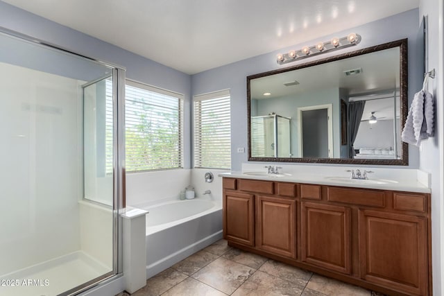 bathroom featuring visible vents, a garden tub, double vanity, a shower stall, and a sink