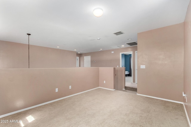 carpeted empty room featuring baseboards and visible vents