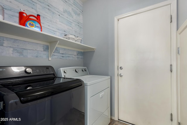 clothes washing area with washing machine and clothes dryer and laundry area