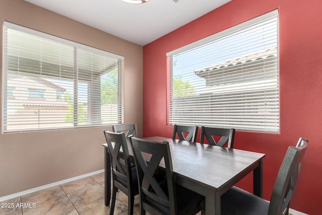 dining space featuring light tile patterned flooring, baseboards, and a wealth of natural light