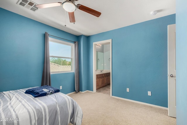 bedroom featuring visible vents, baseboards, ensuite bathroom, light colored carpet, and a ceiling fan