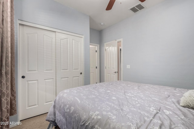 bedroom with a closet, a ceiling fan, carpet flooring, and visible vents