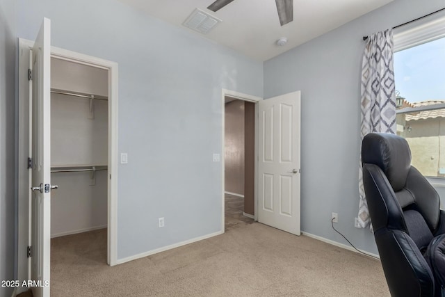 carpeted office space with a ceiling fan, baseboards, and visible vents
