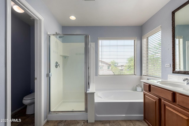 bathroom featuring vanity, a bath, a stall shower, and toilet