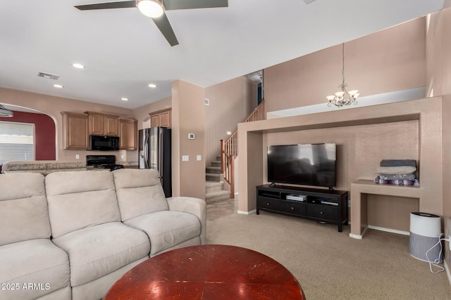 living room featuring visible vents, baseboards, stairway, light colored carpet, and ceiling fan with notable chandelier