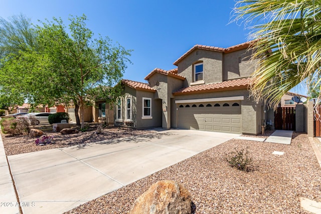 mediterranean / spanish-style home with driveway, a tile roof, and stucco siding