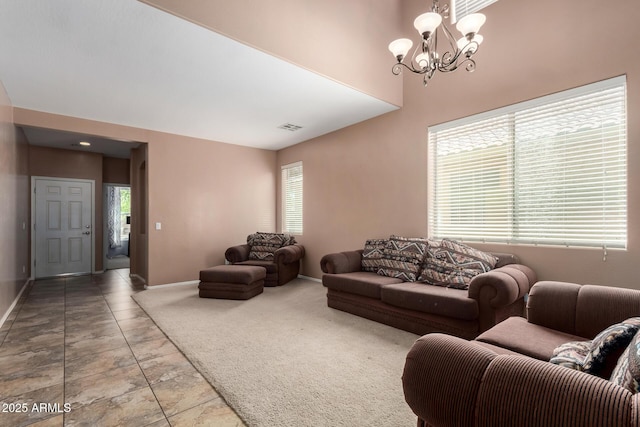 carpeted living area featuring baseboards, a notable chandelier, a towering ceiling, and visible vents