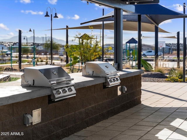 view of patio with area for grilling and a grill