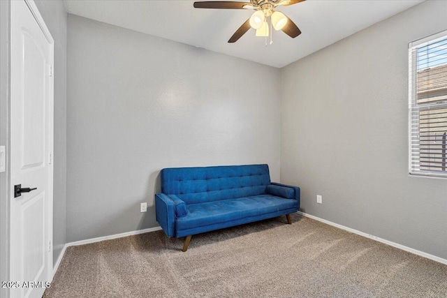 sitting room with carpet floors, baseboards, and a ceiling fan