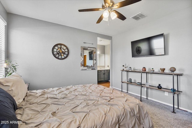 bedroom with baseboards, ensuite bath, carpet floors, visible vents, and ceiling fan