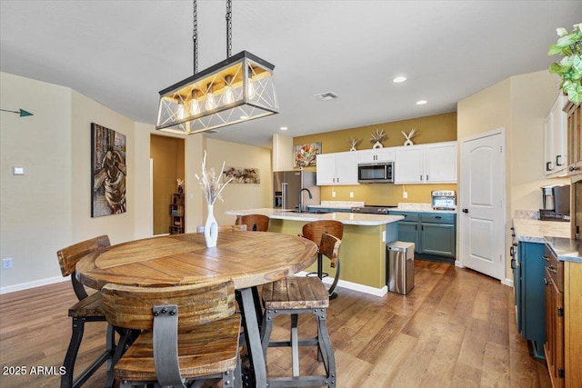 dining space with recessed lighting, visible vents, baseboards, and wood finished floors