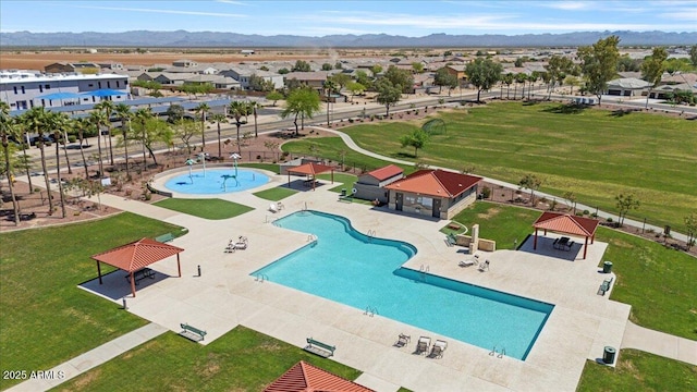 community pool featuring a mountain view, a gazebo, fence, and a patio