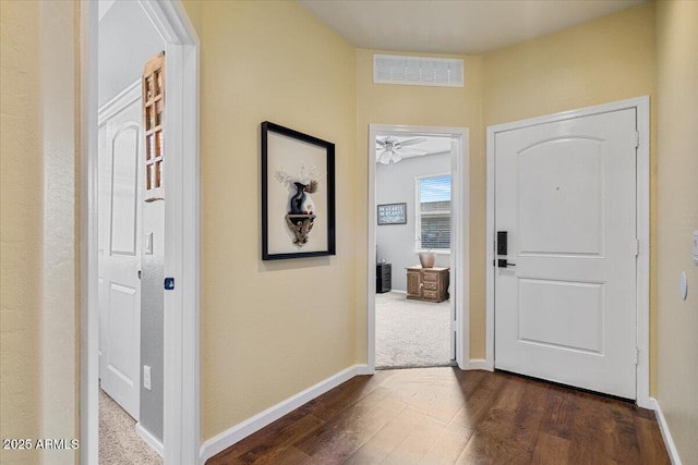 foyer with visible vents, dark wood-style flooring, and baseboards