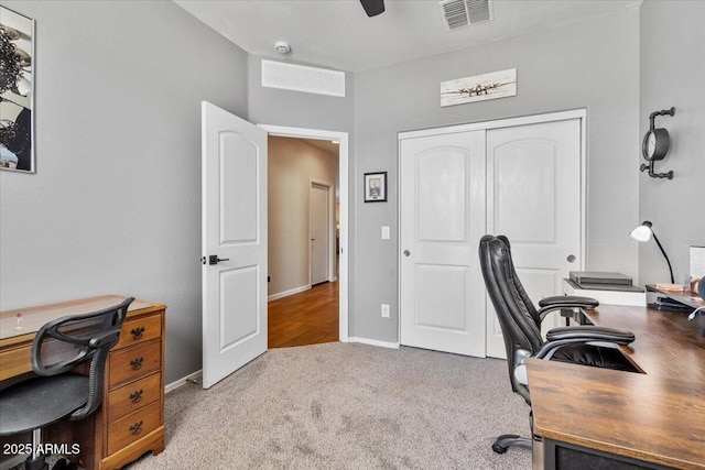 carpeted office space featuring visible vents and baseboards