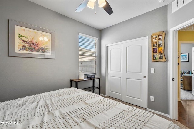 bedroom with a closet, baseboards, and ceiling fan