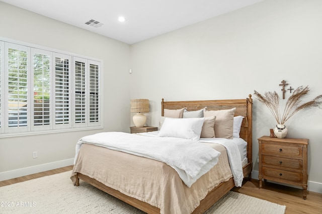 bedroom with recessed lighting, visible vents, baseboards, and wood finished floors