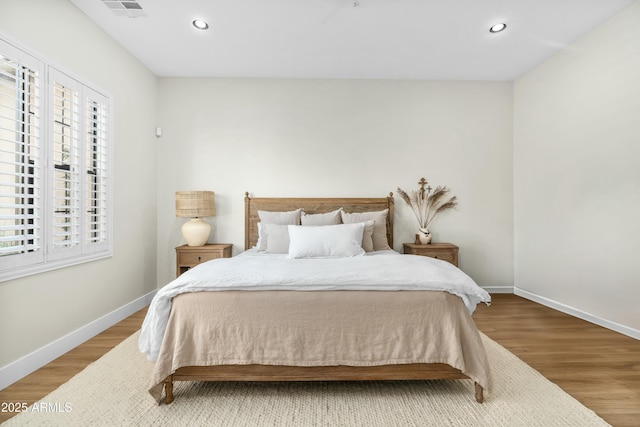 bedroom with recessed lighting, baseboards, and wood finished floors