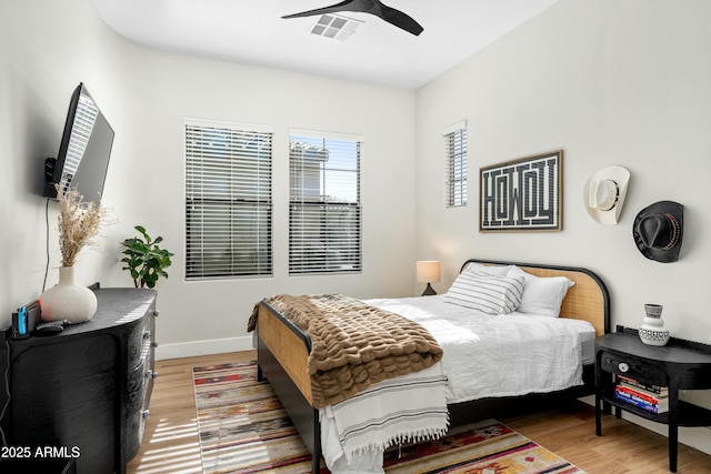 bedroom with a ceiling fan, wood finished floors, and baseboards