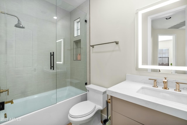 full bath with visible vents, bath / shower combo with glass door, toilet, and vanity