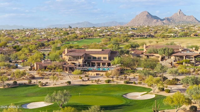 drone / aerial view with golf course view and a mountain view