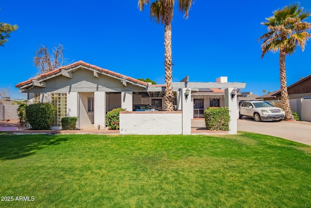 view of front of property with a front yard, fence, and stucco siding