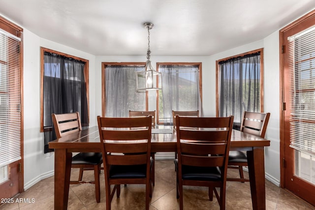 tiled dining room with plenty of natural light and baseboards