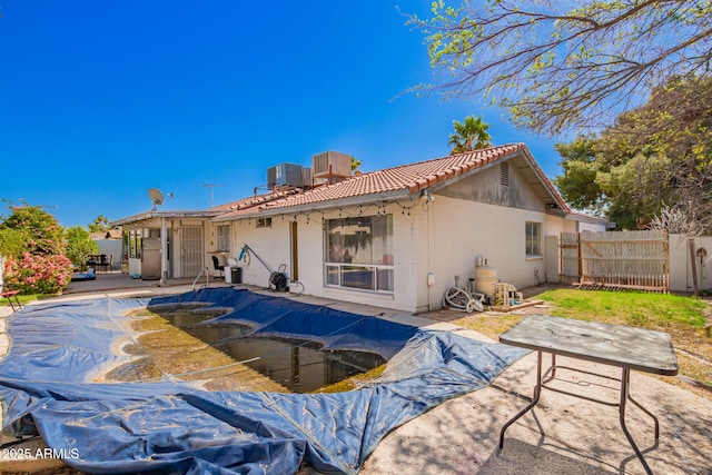 back of house featuring central AC unit, a patio, a tile roof, fence, and stucco siding