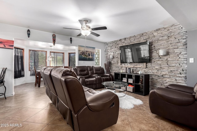 living area with light tile patterned floors and ceiling fan