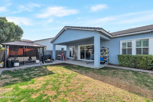 back of property with a gazebo, outdoor lounge area, a yard, and a patio area