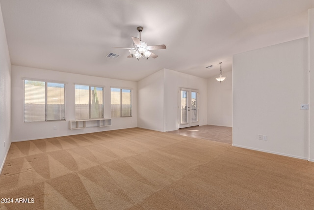 empty room featuring french doors, ceiling fan, and light colored carpet