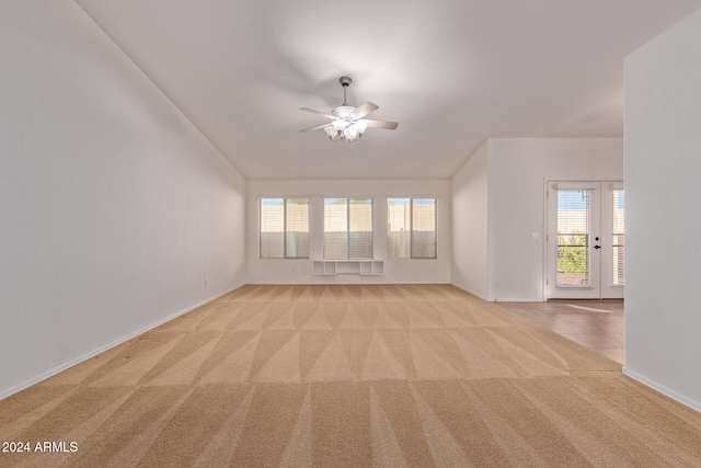 carpeted empty room with french doors, a healthy amount of sunlight, and ceiling fan