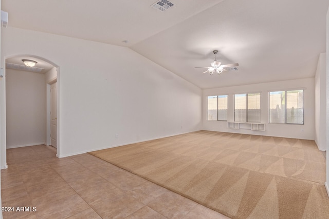 unfurnished living room featuring ceiling fan, light colored carpet, and vaulted ceiling