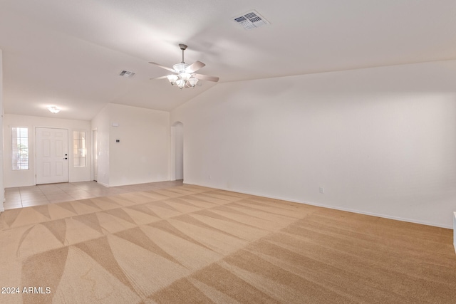 carpeted empty room with vaulted ceiling and ceiling fan