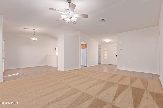 unfurnished room with light carpet, vaulted ceiling, and ceiling fan