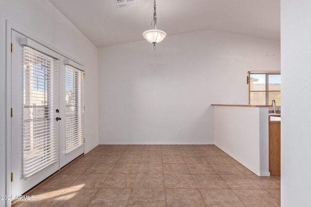 tiled empty room featuring sink, french doors, and vaulted ceiling