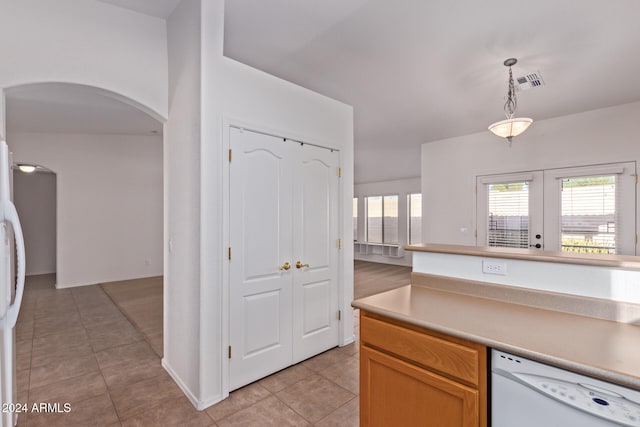 kitchen with white appliances, light tile patterned flooring, french doors, and decorative light fixtures